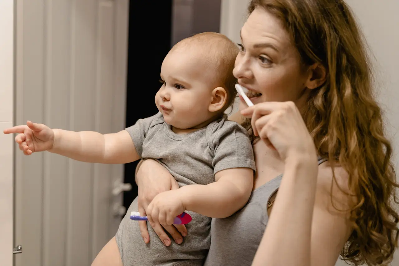 Parent caring for a smiling toddler's teeth in Turlock
